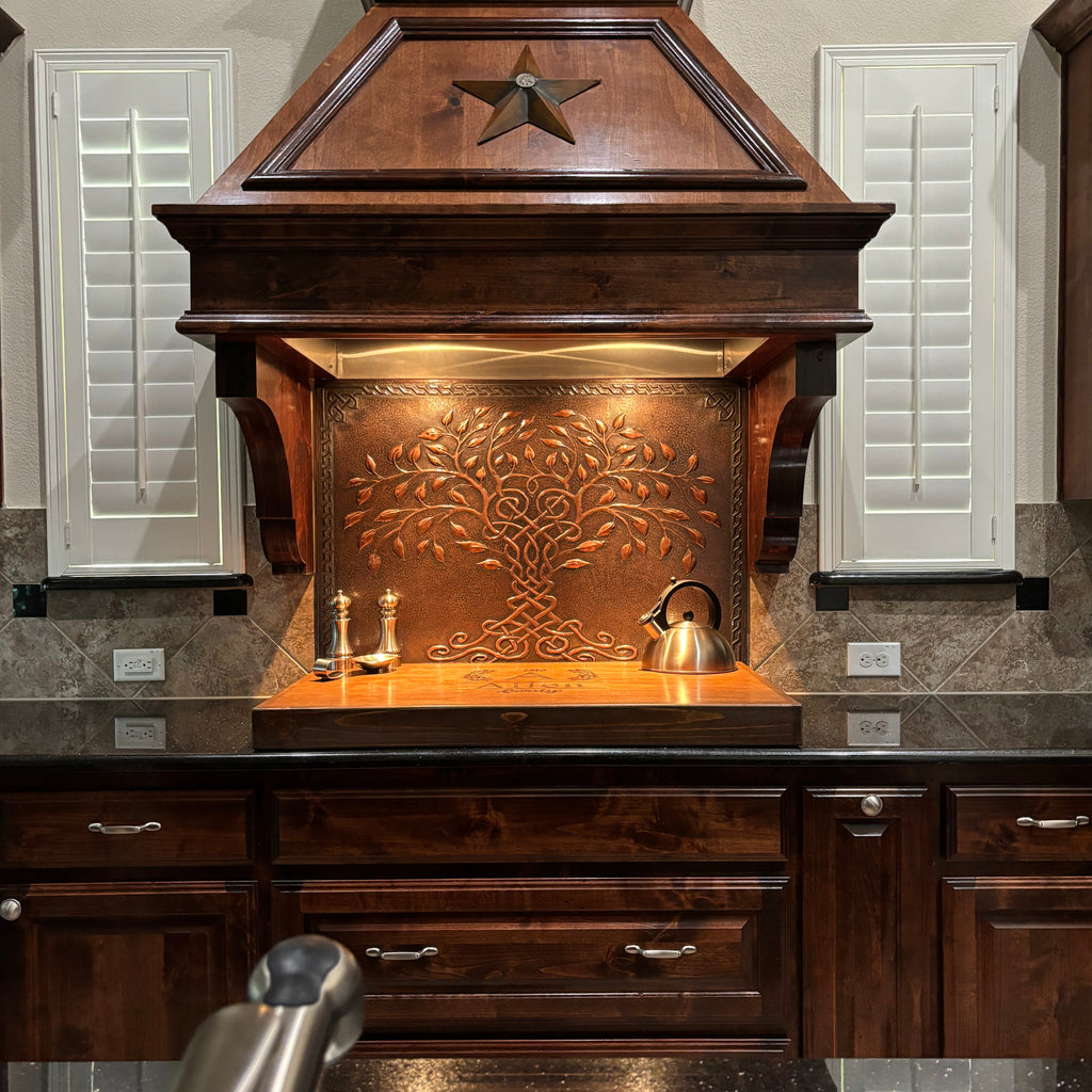 Tre of Life copper  backsplash in a rustic kitchen with wooden cabinets.